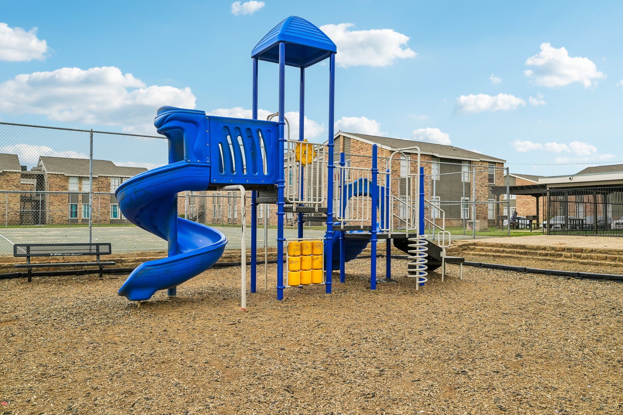A playground with a blue slide and a yellow slide.